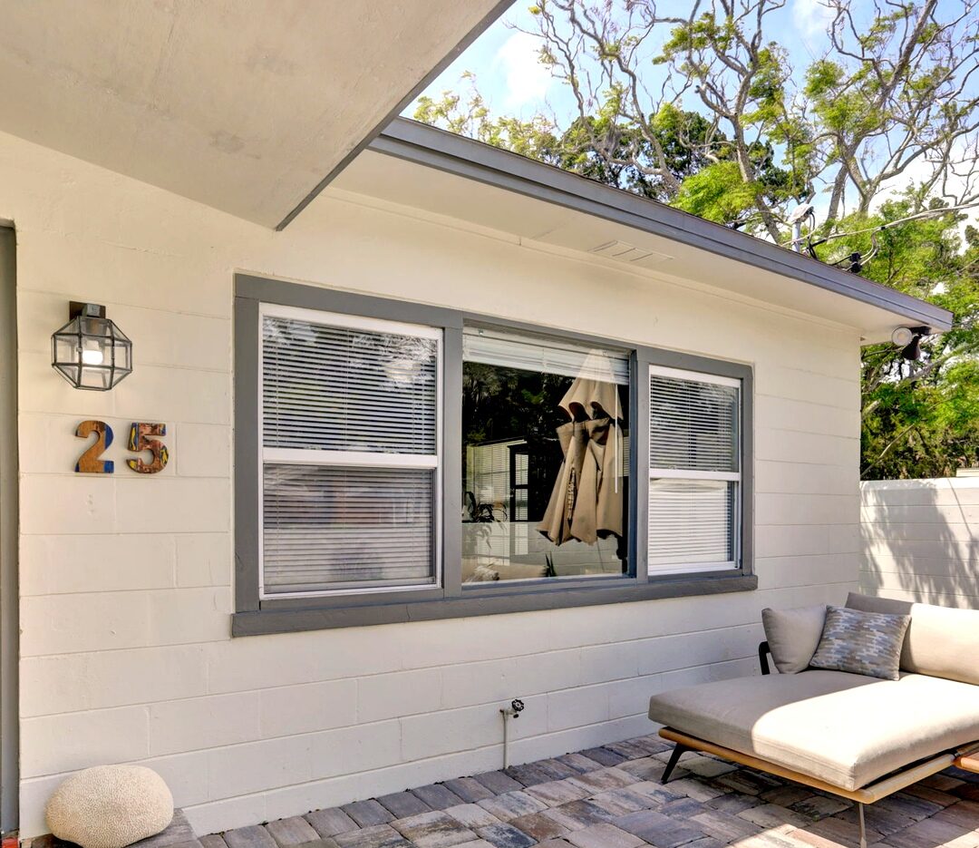 Paver front patio with lounge seating beside the house number 25
