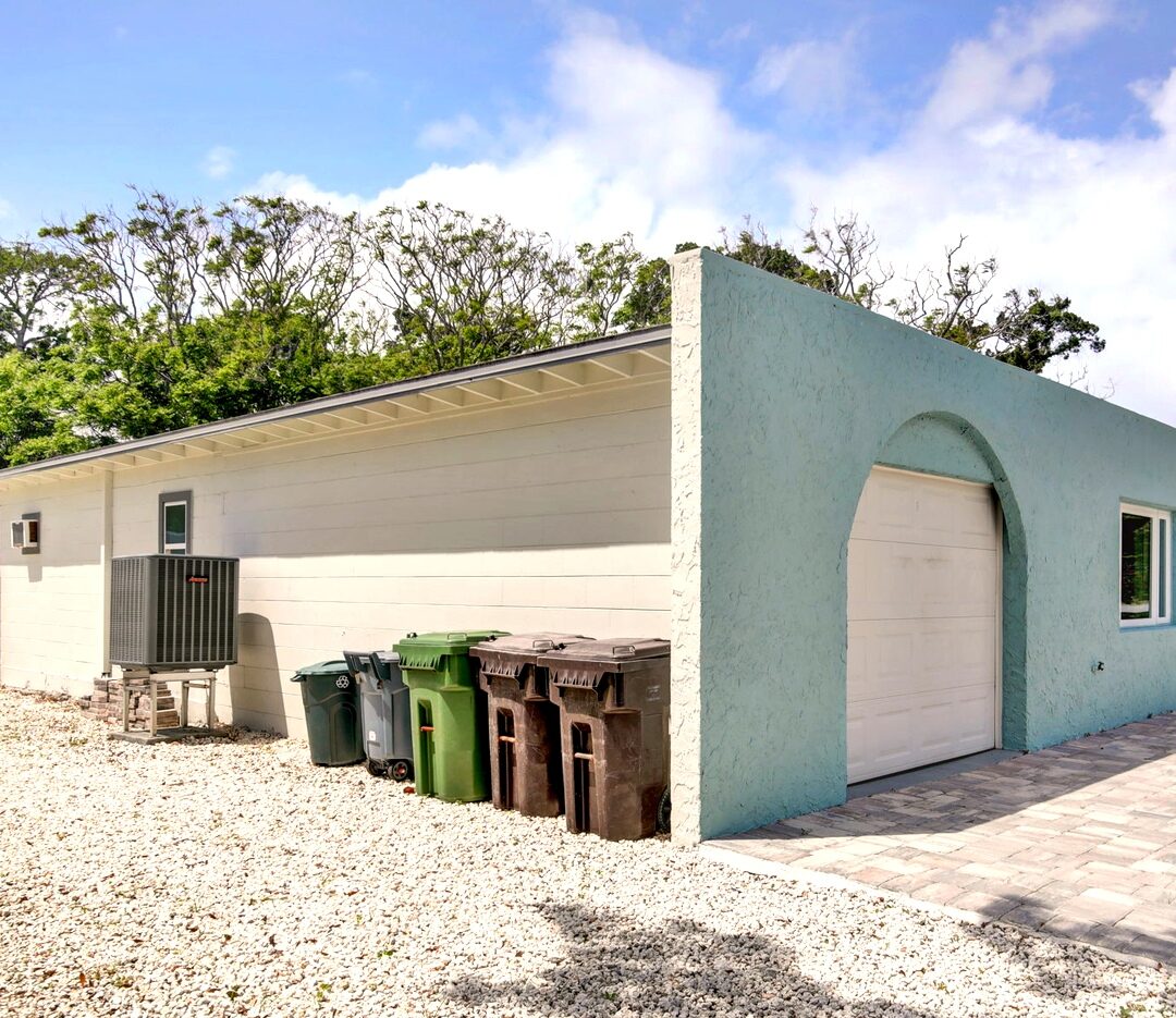 Side of the home showing the arched garage and A/C unit