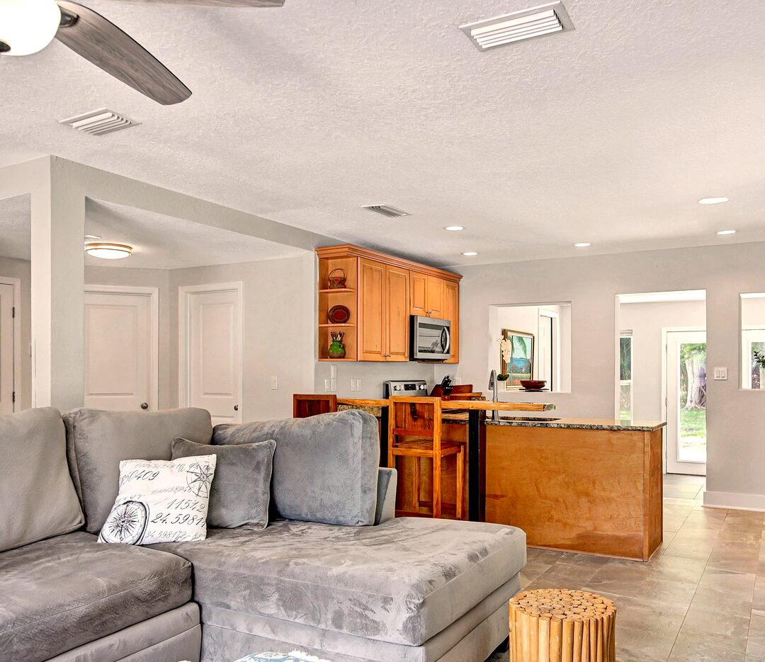 Open-concept living area flowing into the kitchen with granite breakfast bar